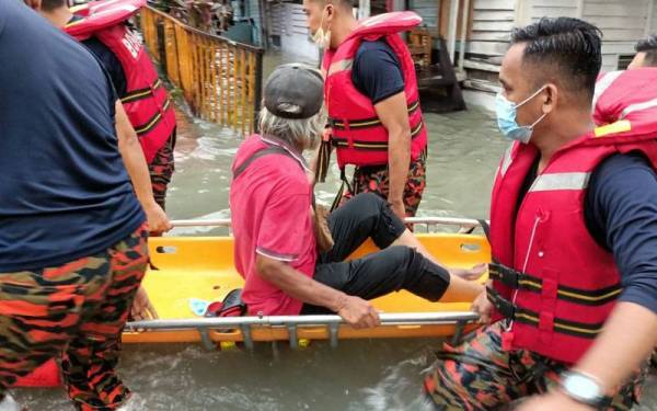 Pasukan penyelamat membawa keluar mangsa banjir di Kampung Periuk, Kampung Baru. - Foto: JBPMKL