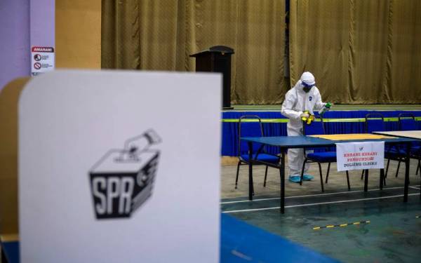 Pekerja pembersihan melakukan tugas sanitasi menjelang pengundian awal bagi PRN Johor di Dewan Serbaguna Perumahan Polis Diraja Malaysia (PDRM) Muar. Foto Bernama