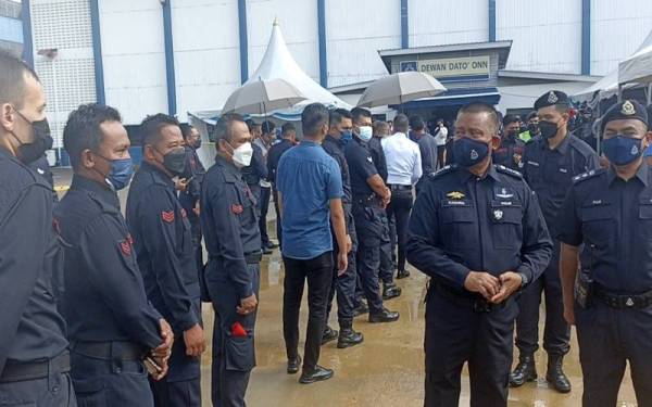 Kamarul Zaman (dua dari kanan) bertegur sapa dengan anggota yang beratur menunggu giliran untuk mengundi awal bagi PRN Johor di Dewan Dato Onn Ibu Pejabat Polis Kontinjen ( IPK) Johor di sini hari ini.