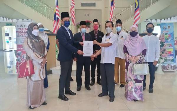 Khir Razlan ((tiga dari kiri) bersama beberapa wakil NGO Islam Melaka menyerahkan memorandum kepada Muhammad Ikram (dua dari kiri) di Bukit Palah pada Selasa.