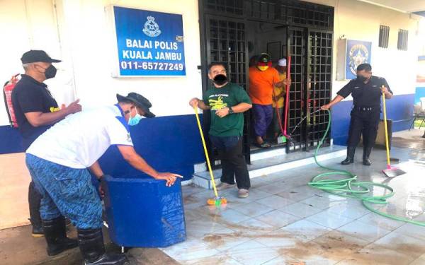 Ketua Polis Daerah Tumpat, Superintendan Mohd Azmir Damiri (kanan) bersama anggota dan orang awam membersihkan Balai Polis Kuala Jambu, Tumpat selepas banjir surut.