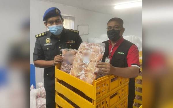Pegawai KPDNHEP dan JHEAINS menunjukkan produk ayam dan burung puyuh sejuk beku yang menggunakan logo halal tidak sah dalam serbuan di sebuah premis di Taman Negeri pada Selasa.