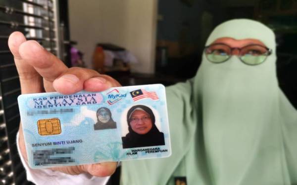 Senyum menunjukkan kad pengenalannya.