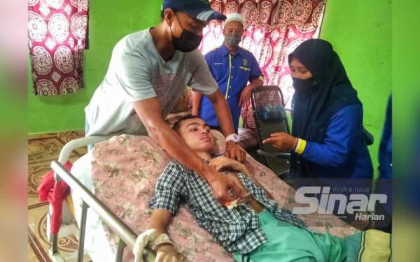 Nor Azmi (kiri) menunjukkan perut yang ditebuk pada Afiq untuk menyalurkan susu.