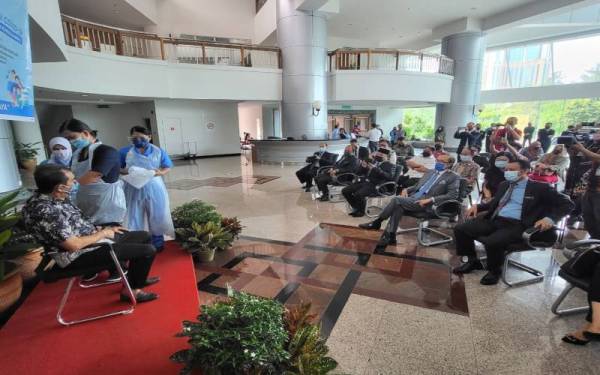 Masidi (dua dari kanan) hadir melihat proses pemberian vaksin bagi dos penggalak dan kanak-kanak di lobi Wisma Innoprise, Kota Kinabalu pada Khamis.