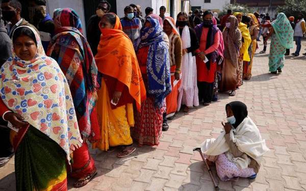 Orang ramai beratur untuk membuang undi di luar pusat mengundi semasa pilihan raya DUN di bandar Vrindavan. Foto Reuters