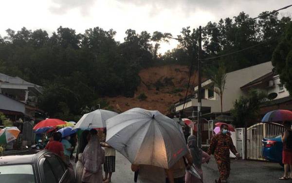 Orang ramai menyaksikan kejadian tanah runtuh di Taman Bukit Permai, Ampang, lewat petang Khamis.