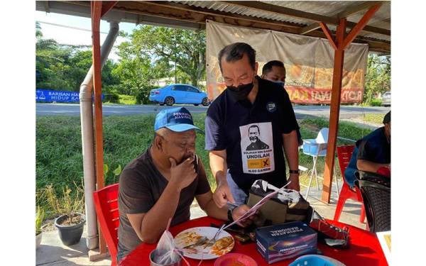 Mohd Solihan (kanan) ketika beramah mesra bersama penduduk DUN Gambir ketika berkempen di Parit Kassan pada Isnin. 