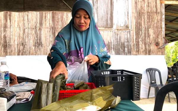 Ibu tujuh anak, Hasliza Salleh, 46, menunjukkan tepung bungkus yang dihasilkannya dan dijual dengan harga 40 sen sebiji. 