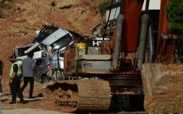 Anggota polis memantau keselamatan kawasan perumahan yang berlaku insiden tanah runtuh di Taman Bukit Permai 2, Ampang pada Khamis. - Foto Bernama