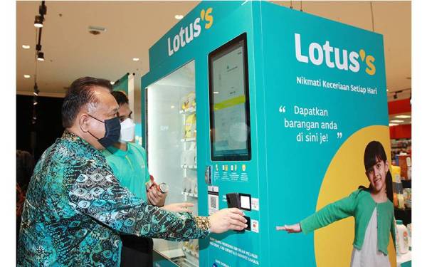 Salah seorang wakil Lotus's sedang memberi penerangan mengenai mesin layan diri Lotus's.