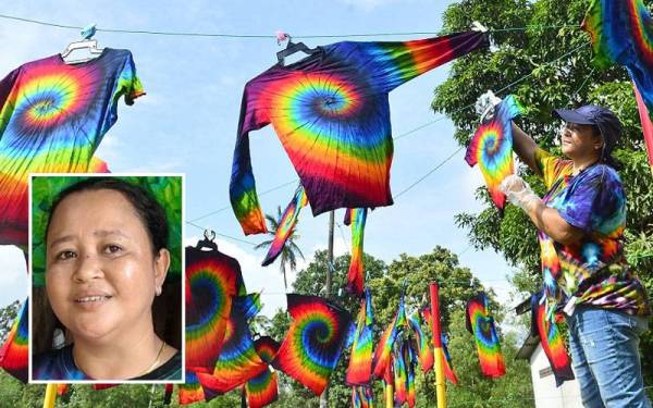Dewi Susanty menjemur pakaian yang sudah siap dihasilkan melalui proses tie dye di Kampung Cherating pada Sabtu. Gambar kecil: Dewi Susanty