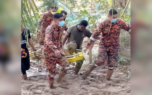 Pasukan penyelamat mengusung mangsa sebaik berjaya dikeluarkan daripada lumpur dalam kejadian di Kampung Teladas, Air Putih di Kemaman.