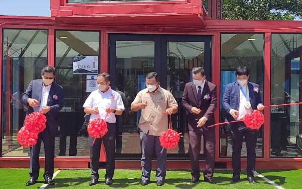 Suee Lim (dua dari kiri), Amirudin (tengah) dan Ngan Choy (dua dari kanan) memotong reben merasmikan projek perumahan Ion Belian Garden pada Sabtu.