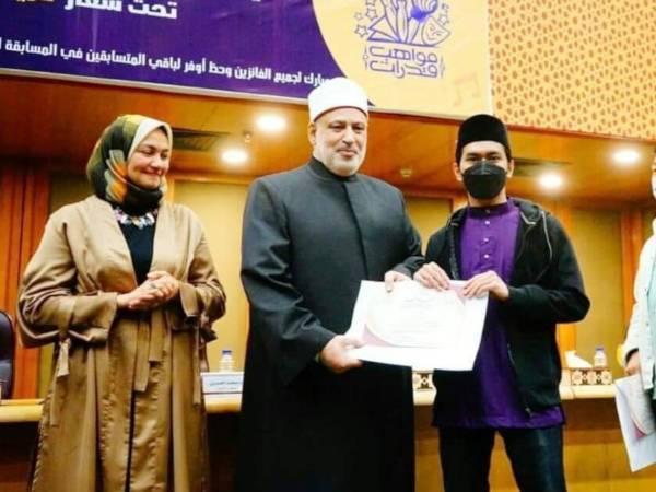 Muhammad Afiq (kanan) menerima penghargaan sempena Pertandingan Kemahiran Dan Bakat Pelajar Antarabangsa Universiti Al-Azhar 2022 di Pusat Konvensyen Azhar, di Kaherah, Mesir.