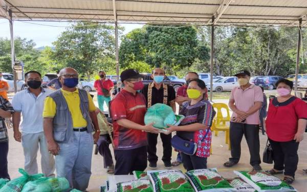 Ewon menyampaikan bakul makanan kepada ketua isi rumah dalam Mukim Kelawat dan Kinasaraban, Kota Belud, pada Ahad.
