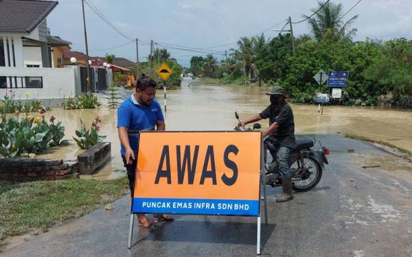 Tanda awas diletakkan di kawasan banjir di Desa Seri Chepor, Chemor.