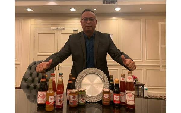 Mohd Nazri menunjukkan produk keluaran Zara Foodstuff Industries Sdn Bhd bersama trofi Anugerah Ikon Usahawan Negeri Johor 2021.