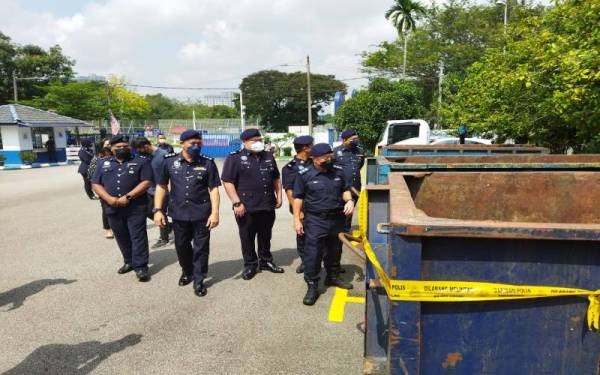 Beh Eng Lai (kanan) melihat tong RORO yang dirampas di Balai Polis Jinjang.