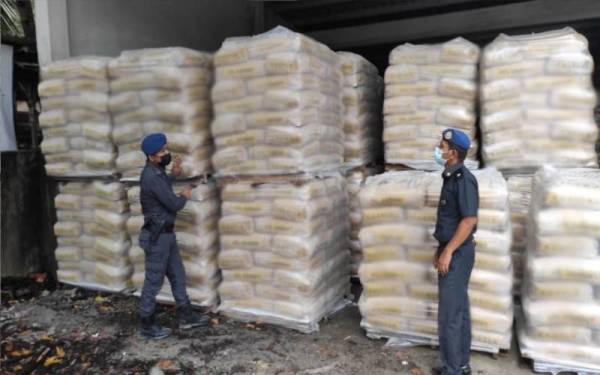 Pegawai KPDNHEP Perak menjalankan pemeriksaan sebuah premis yang menyimpan simen tanpa lesen sah di Ipoh. - Foto ihsan KPDNHEP Perak