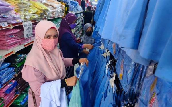 Rose Diawati memilih pakaian sekolah agama untuk anaknya di sebuah kedai pakaian di bandar ini.