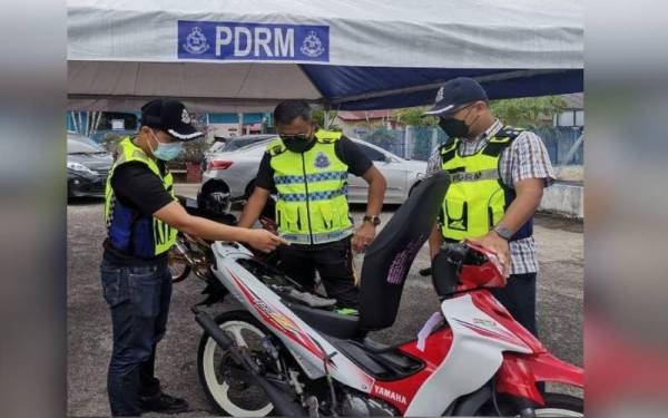 Polis memeriksa motosikal yang ditahan dalam Op Samseng Jalanan pada Khamis.