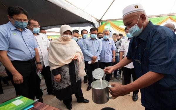 Zuraida (tiga dari kiri) melihat Penasihat MHJ Enterprise Zulkifly Abdullah (kanan) membuat demonstrasi penggunaan alat untuk mendapatkan kandungan getah kering sempena Majlis Pelancaran Pengeluaran Lateks di Bukit Bunga pada Sabtu. - Foto Bernama