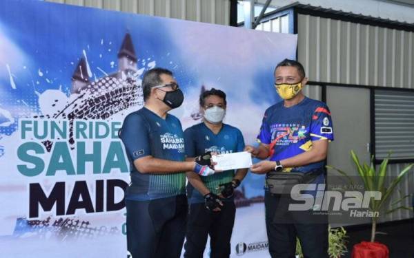 M Rozi (tengah) menyaksikan penyerahan bantuan modal kepada salah seorang penerima.