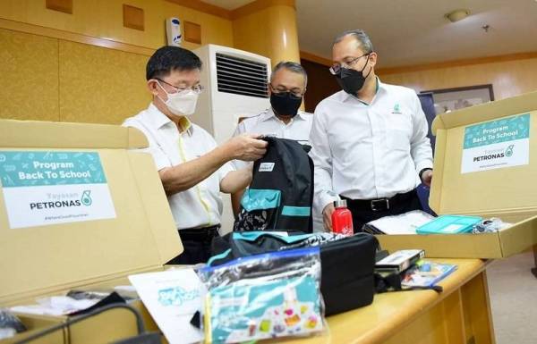 Kon Yeow (kiri) melihat barangan bantuan BTS 2022 yang disumbangkan oleh Yayasan Petronas pada Sabtu.
