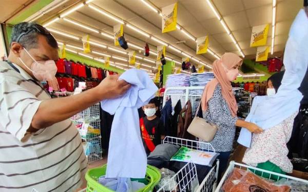 Kunjungan Ahmad Nazri (kanan) pada saat akhir di premis barangan sekolah adalah untuk melengkapkan keperluan sekolah dua anaknya.