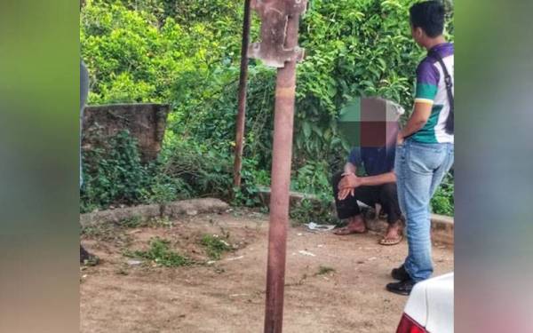 Lelaki OKU (duduk) ditemukan selamat oleh orang awam selepas dilaporkan hilang dalam kebakaran di Felda Sungai Nerek pada Ahad. - Foto ihsan bomba