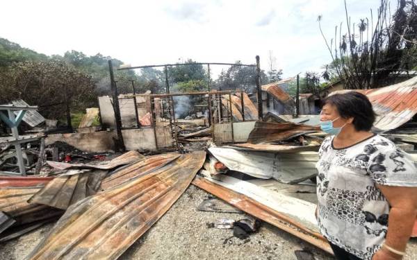 Pann Kam Mooi melihat rumahnya yang musnah dalam kebakaran pada Ahad.
