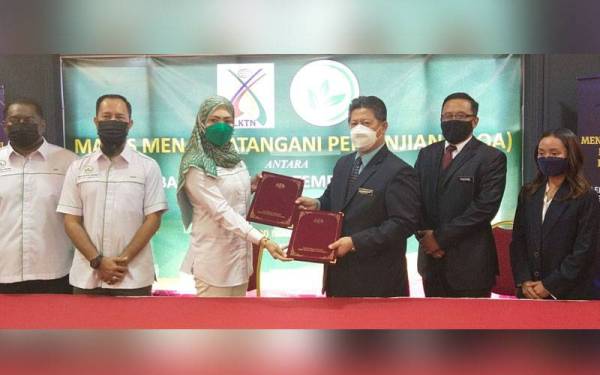 Idris (tiga dari kanan) dan Azjuriyahti bertukar dokumen perjanjian pada Majlis Menandatangani Perjanjian Kerjasama antara LKTN dan KMDI di sini pada Ahad.