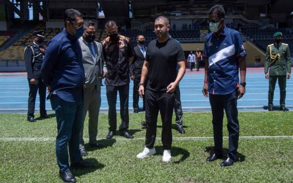 Tunku Ismail (dua dari kanan) berkenan mencemar duli hadir meninjau keadaan padang di Stadium Nasional, Bukit Jalil pada Sabtu.  Turut sama Menteri Belia dan Sukan, Datuk Seri Ahmad Faizal Azumu (kiri).   - Foto Bernama