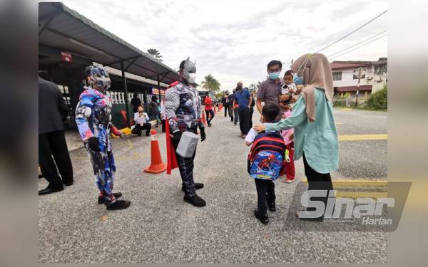 Optimus Prime dan Thor menyambut murid datang ke sekolah.