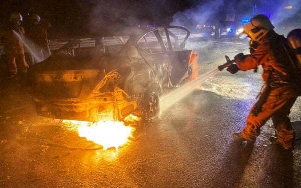 Anggota bomba sedang memadamkan kebakaran kereta yang terlibat dalam kemalangan di Kilometer 58.2 Lebuhraya Utara Selatan di sini awal pagi Isnin.