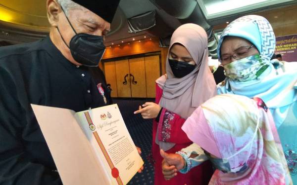 Sharudin menunjukkan sijil penghargaan kepada isteri dan cucunya selepas Majlis Istiadat Penganugerahan PJPN Kontinjen Negeri Sembilan pada Isnin.