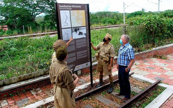 Pengerusi Persatuan Sejarah Malaya (MHG) Shaharom Ahmad (dua, kanan) menunjukkan papan tanda yang baharu dibina berkenaan maklumat tapak peninggalan sejarah Jambatan Victoria di Enggor Karai hari ini.