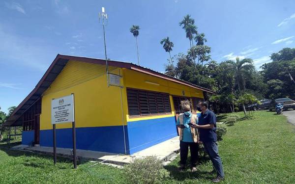 Rizal (kanan) dan Raman memeriksa liputan rangkaian internet di Perkampungan Orang Asli Sungai Judah, Selangor yang semakin lancar selepas pelaksanaan Jendela di kawasan berkenaan.
