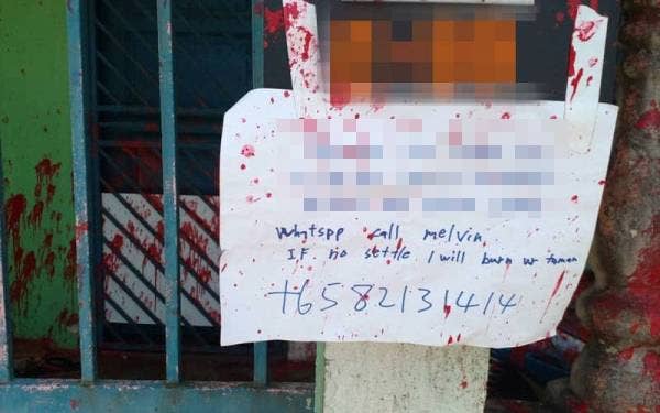 Sekeping nota ugutan yang tertera nama dan alamat ditinggalkan ah long berkenaan di hadapan rumah mangsa di Taman Muhibbah, Ulu Tiram, Johor Bahru.