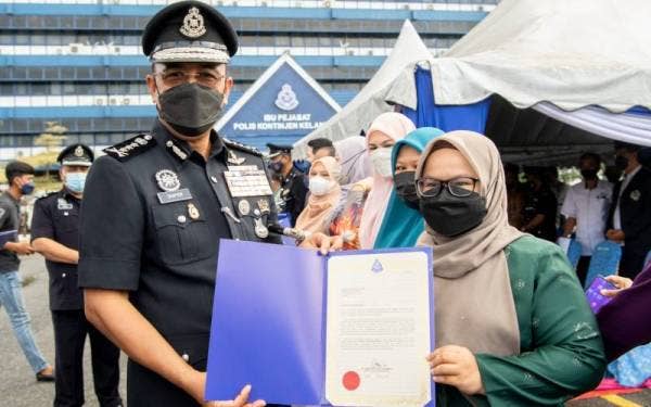 Shafien (kiri) menyampaikan sijil penghargaan kepada Ketua Wartawan Sinar Harian Kelantan, Hazelen Liana Kamarudin sempena Sambutan Peringatan Hari Polis ke-215 Kontinjen Kelantan di pekarangan IPK Kelantan pada Jumaat.