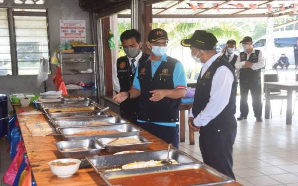 Dr Mohd Anuar memeriksa makanan di sebuah premis di daerah Kemaman dalam operasi berkenaan.