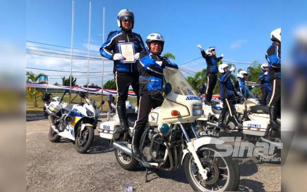 Koperal Mohd Supiyan (kiri) berdiri di atas motosikal berkuasa tinggi PDRM melakukan persembahan pada Sambutan Hari Polis ke -215.