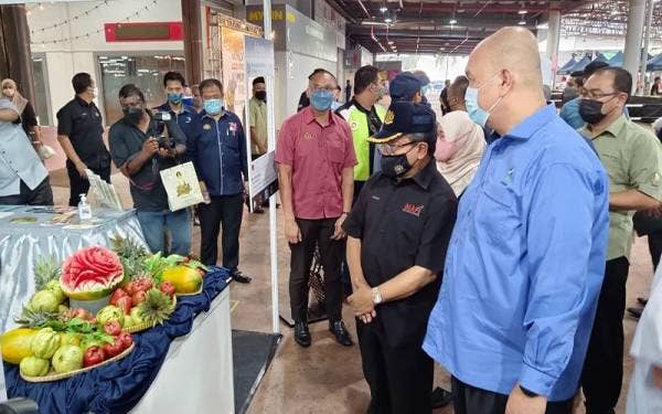 Pengarah FAMA Perak, Noorsham Ramly (kanan) mengiringi Ahmad melawat gerai FAMA di RTC Gopeng.