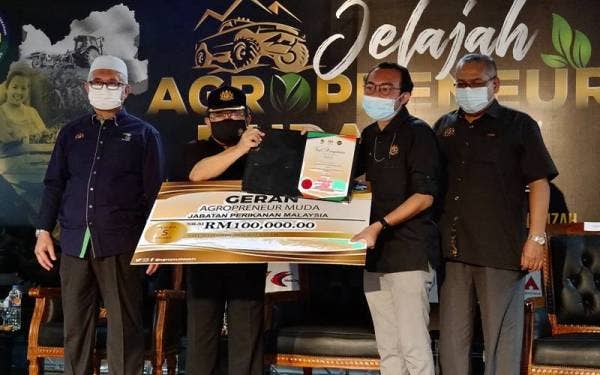 Ahmad (dua dari kanan) menyampai replika cek kepada Jabatan Perikanan Perak.