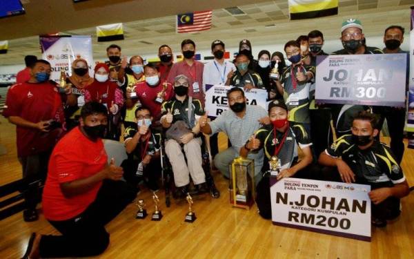 Khairul Shahril (duduk, tengah) ketika sesi bergambar bersama peserta boling tenpin pada Pertandingan Boling Tenpin Para Negeri Perak 2022 di Ampang Superbowl Seri Iskandar pada Sabtu. - Foto Bernama