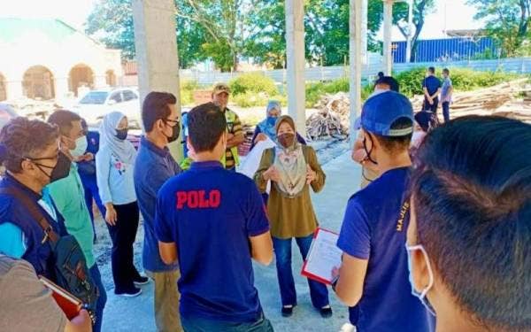 Noraini (tengah) turun padang bersama pasukan petugas dalam membuat pemantauan di kawasan perindustrian Bandar Sultan Suleiman di sini.