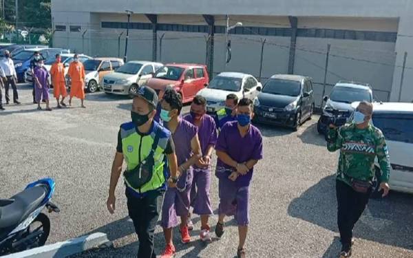 Tertuduh yang terdiri daripada tiga lelaki tiba di perkarangan Mahkamah Kuala Pilah pada Isnin.