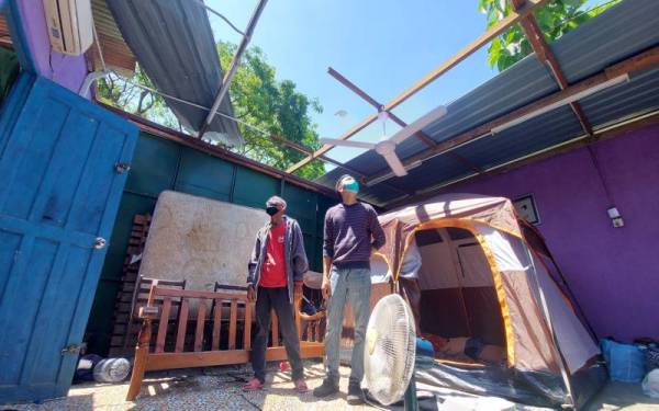 Mohd Abdullahshah membina khemah selepas bumbung rumah diterbangkan angin pada Isnin.