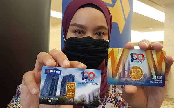 Pegawai Komunikasi Korporat RMS, Aimi Azman memegang dua keping Siri Emas Edisi Khas sempena sambutan 100 tahun gerakan koperasi pada majlis pelancarannya di Menara Kembar Bank Rakyat, Kuala Lumpur pada Rabu.